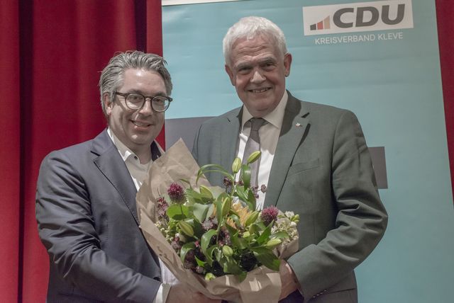 Zwei Herren bei einer Veranstaltung der CDU mit Blumenstrauß.